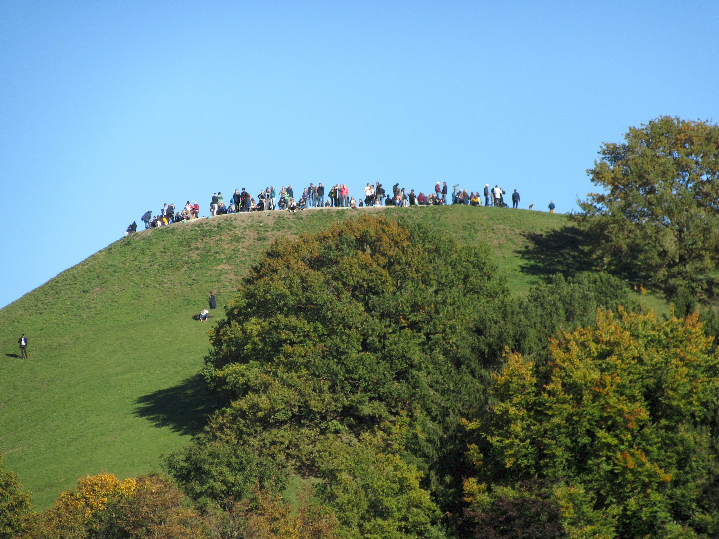 Many people standing on the top of the Olympic mountain