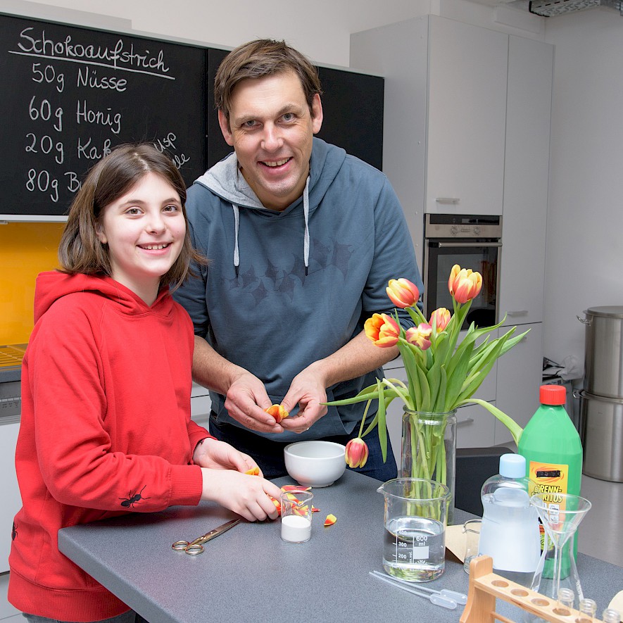 Versuchsaufbau mit Vater und Tochter: Tulpen, Brennspiritus und weiterem Material