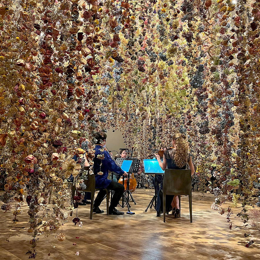 Musiker:innen in der floralen Installation „Calyx“ von Rebecca Louise Law
