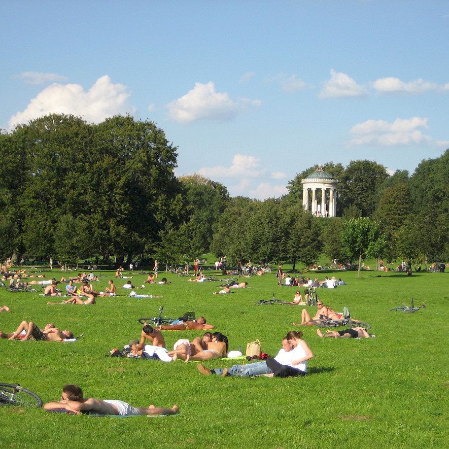Lawn for sunbathing in the English Garden with the Monopterus temple.