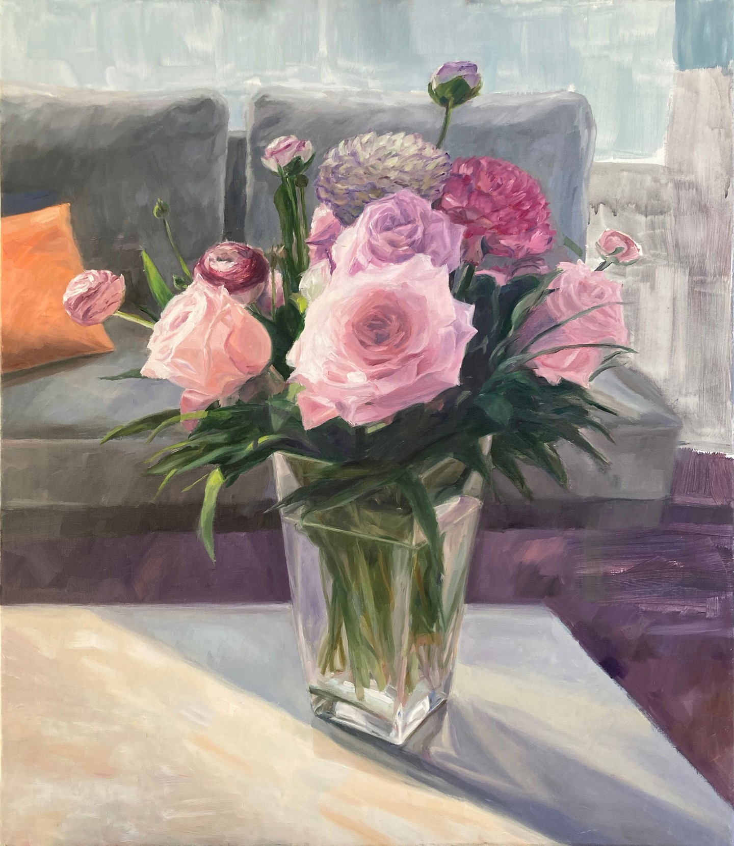 Pink roses and ranunculus in gals vase on a table